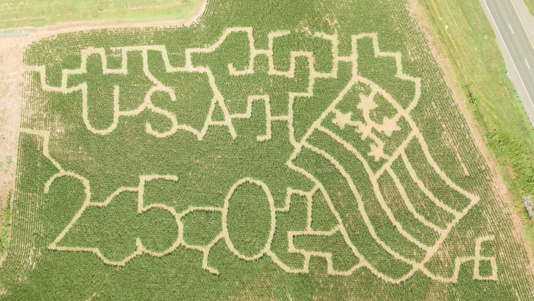 Overhead view of the 2026 Deer Run Farm corn maze featuring USA lettering, a waving American flag, and part of the large 250 design